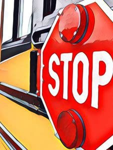 A stop sign is attached to the side of a yellow school bus.