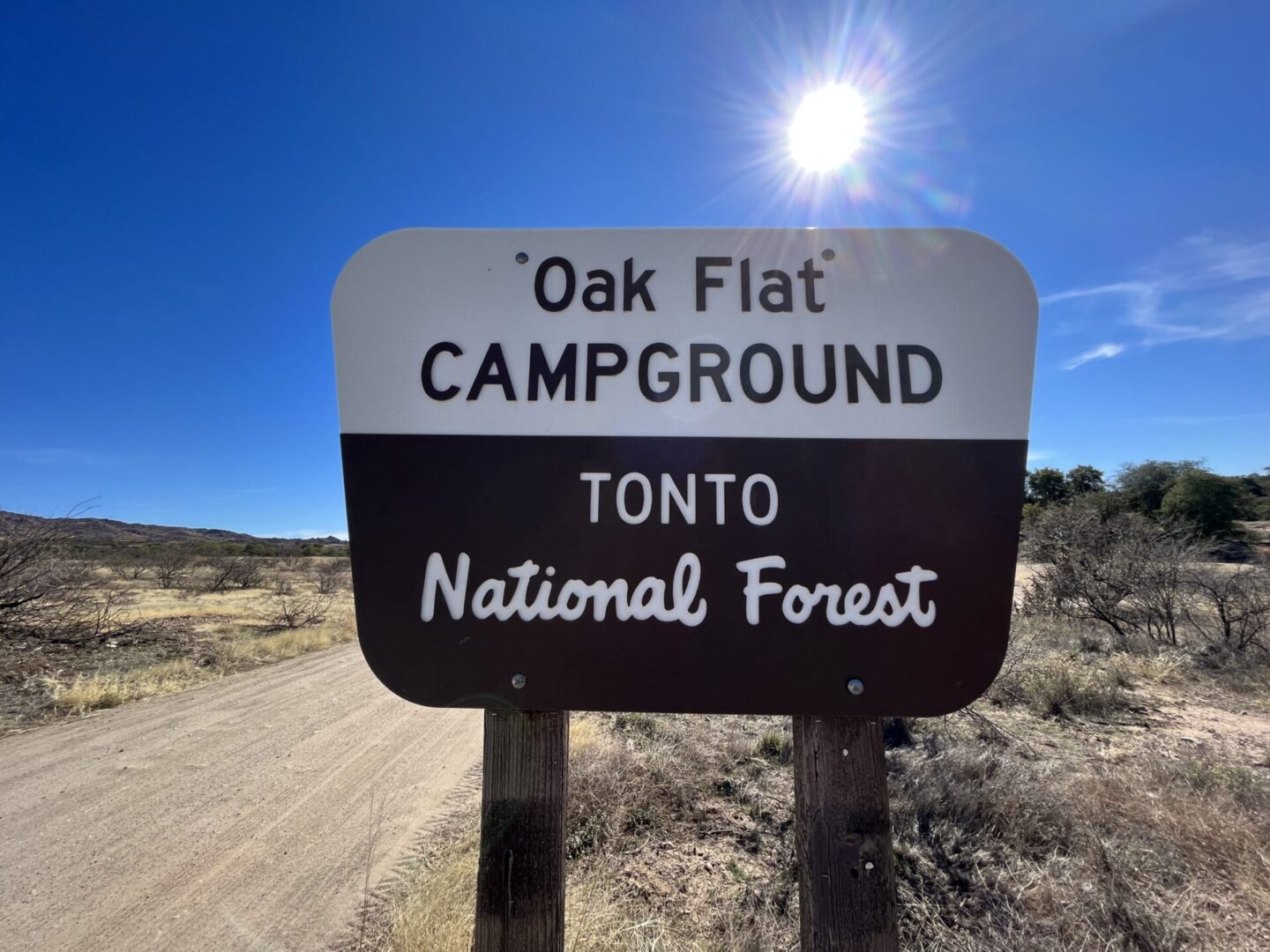 A sign marks the entrance to Oak Flat Campground in Tonto National Forest under a clear, sunny sky.
