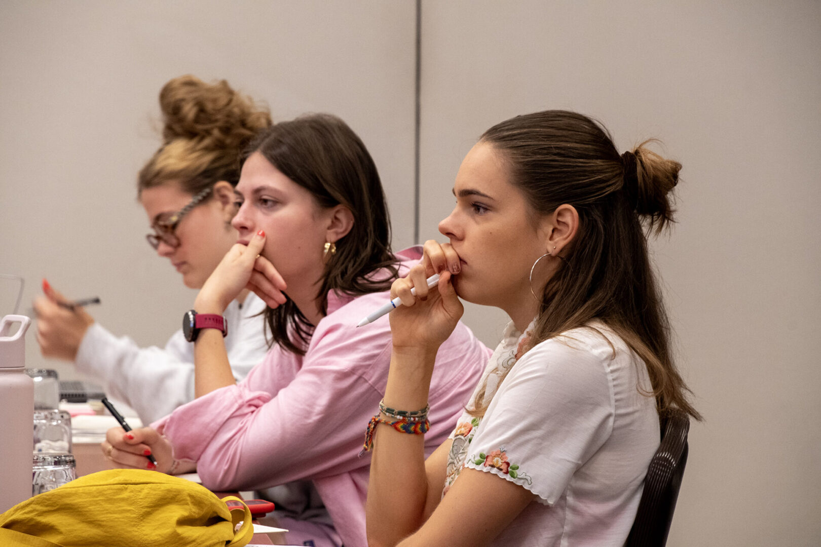 Several individuals are attentively listening during an indoor event.