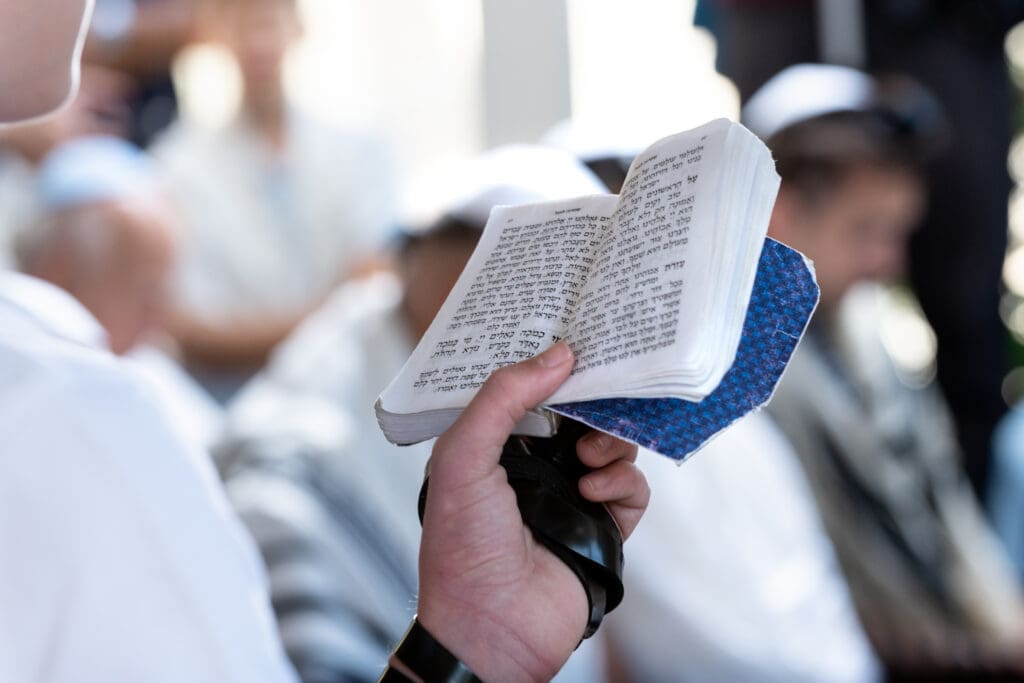 A man holds a Jewish prayer book