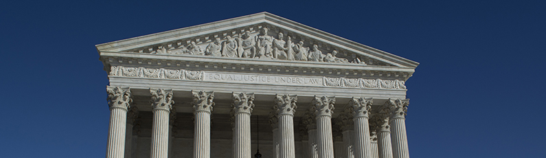 Roofline of the white marble Supreme Court Building in Washington DC