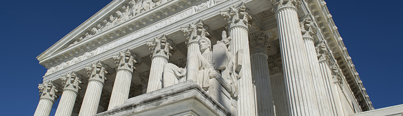 photo of the Supreme Court Building, with White columns and a statue in front