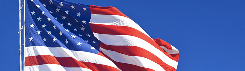 American flag waving in blue sky